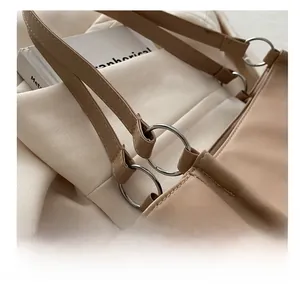 Detail of silver metal ring connecting the soft leather shoulder strap on a beige tote bag