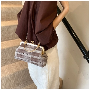 Lifestyle view of a vintage plaid handbag with lace trim and gold metal handles