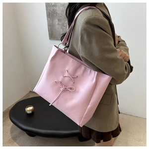 Detailed close-up of pink ballet-style tote bag featuring ribbon lacing and metal eyelets