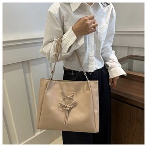 Detail of beige tote bag with lace-up ribbon design and sturdy top handle