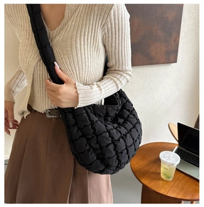 Detail of a black quilted cloud bag showing the puffy nylon texture and crescent shape