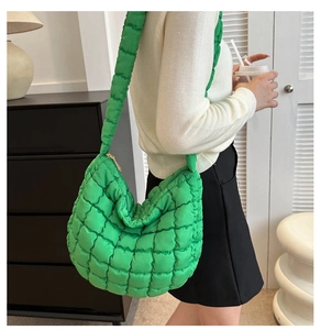 Macro detail of vibrant green quilted hobo bag with high-gloss nylon cloud puff texture