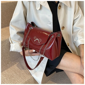 Dark red patent leather tote bag with silver bow detail and chain strap for women