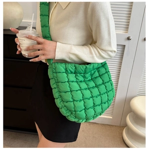 Close-up of bright green quilted puffy tote bag showing soft nylon texture and stitching