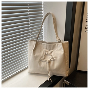 Detailed view of white minimalist tote bag with decorative bow and soft texture