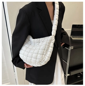 Detailed texture of white quilted cloud bag on a shoulder strap for daily fashion