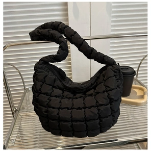 Detailed macro shot of the black quilted bubble texture and puffy fabric of the tote bag