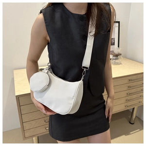 Close-up of a white crescent shoulder bag with a round coin pouch on a nylon strap