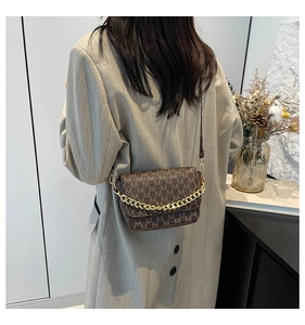 Detail of a brown monogram square crossbody bag with gold chain and leather strap