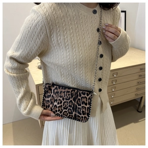 Detail of leopard print crossbody bag featuring silver metal rivets and elegant chain strap