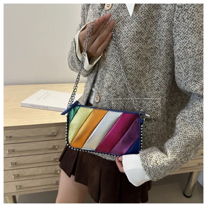 Close-up of rainbow striped crossbody bag featuring silver studs and elegant chain strap