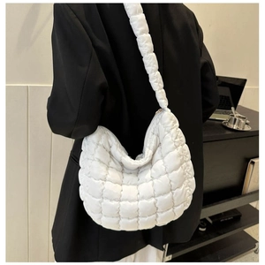 Minimalist white quilted puffer tote bag with thick shoulder strap worn on model