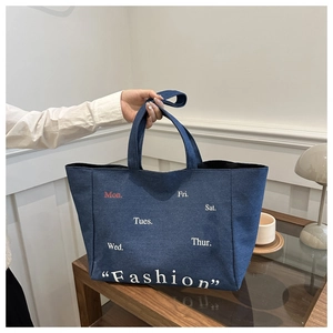 Deep blue denim tote bag with Fashion lettering shown in a stylish lifestyle setting