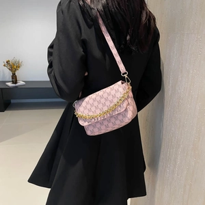 Pink crossbody bag with M-letter monogram pattern and gold chain strap on model