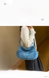 Detail of blue denim crossbody tote bag showing functional side pockets and washed texture