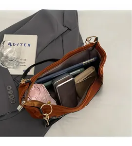 Macro shot of spacious interior in a brown suede tote bag holding daily essentials