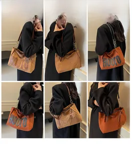 Detail of caramel suede tote bag featuring HOOTO lettering and metal chain strap