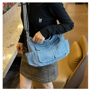 Light blue vintage washed denim crossbody tote bag with multi-pocket utility design