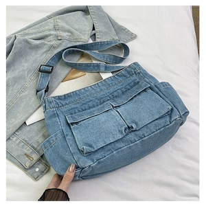 Detail view of retro denim crossbody bag with adjustable strap and dual front pockets