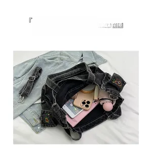 Detail view of large denim tote bag interior showing organized storage for gadgets and umbrella