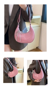 Pink patent leather half-moon bag featuring a stylish silver beaded bow charm detail