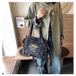 Detail of embroidered lettering and metal chains with pearls on a denim tote bag