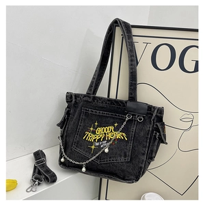 Detail of vintage black denim tote bag with yellow embroidery and pearl chain