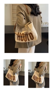 Close-up of premium white canvas tote bag with HOOTO logo and leather chain strap