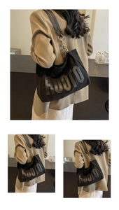 Detail of the black canvas tote bag featuring HOOTO letter patch and metal chain strap