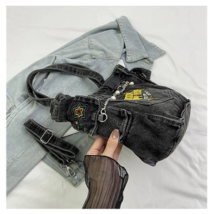 Detail of black denim tote with star embroidery, pearl chain and metal zipper hardware