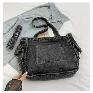 Detail of vintage washed denim tote bag showing colorful star embroidery and pockets