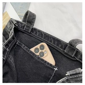 Close-up of denim tote interior featuring functional pockets and secure zipper closure