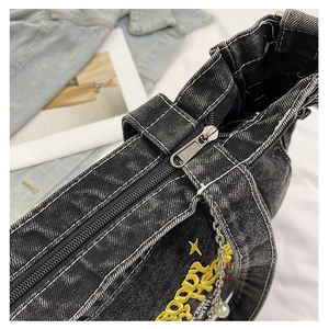 Detail of washed denim tote with yellow embroidery, white contrast stitching and pearl chain