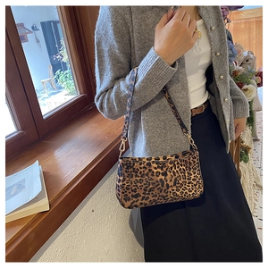 Dettaglio della texture leopardata vintage e fibbia dorata sulla borsa sottospalla