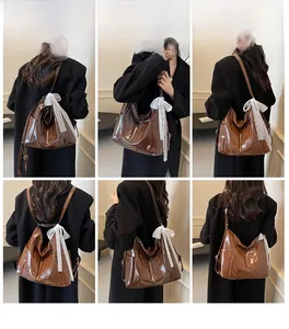 Vue détaillée du sac cabas marron brillant avec nœud en dentelle blanche et poches
