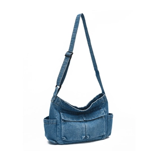 Denim crescent crossbody bag with multiple pockets and adjustable strap shown at 45 degrees