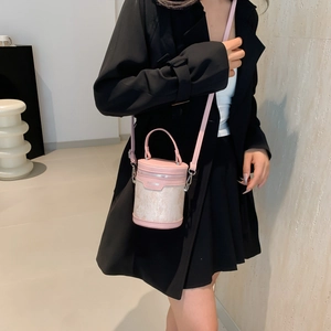 Pink cylindrical bucket bag with marble texture, styled on a model in a modern room