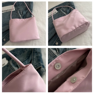 Detail of light pink nylon shoulder bag featuring magnetic buckle and soft inner lining