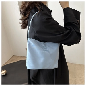 Detail of light blue nylon bag with pretty and libety embroidery and single handle