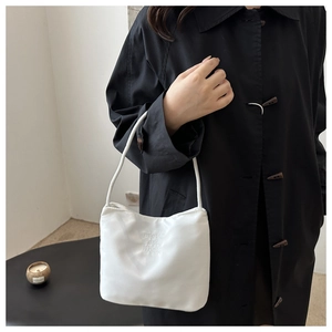 Detailed embroidery on white nylon shoulder bag with elegant minimalist strap design
