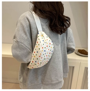 Polka dot waist bag shown on model highlighting compact size and adjustable strap
