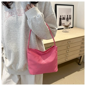 Detail of pink nylon shoulder bag featuring chic 'pretty and liberty' embroidery texture