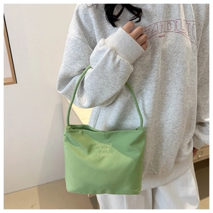 Close-up of light green nylon bag with pretty and libety embroidery details
