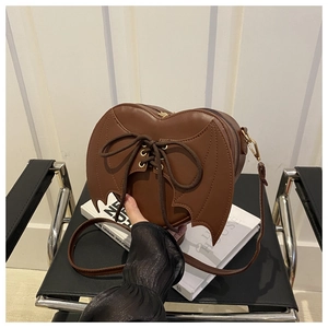 Détail du sac à bandoulière en forme de cœur avec ailes de chauve-souris et lacets