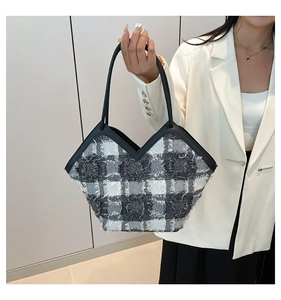 Détail du sac cabas en tweed avec motif à carreaux noir et blanc et bords à franges