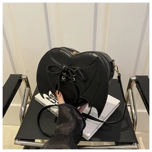 Vue détaillée du sac bandoulière noir en forme de cœur avec ailes de chauve-souris et lacets