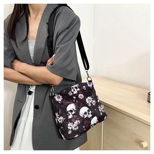 Close-up of vintage skull and purple floral jacquard pattern on a black shoulder bag