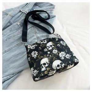 Detail of gothic floral skull pattern on shoulder bag with adjustable silver buckle