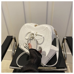 Détail du sac à bandoulière blanc en forme de cœur avec ailes de chauve-souris
