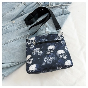 Detail view of gothic skull and floral jacquard pattern on shoulder bag with back zipper